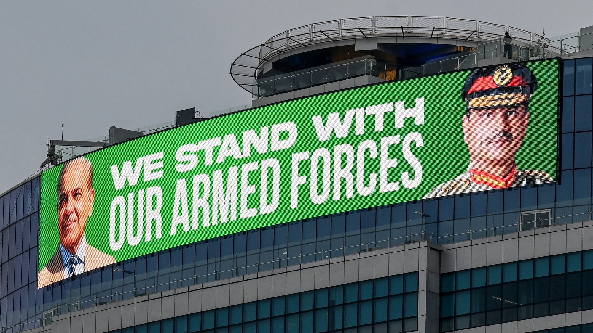 A large screen displaying images of Pakistan's Prime Minister Shehbaz Sharif and the country's Chief of Army Staff General Syed Asim Munir, in Islamabad