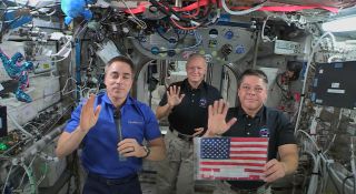 NASA astronauts Chris Cassidy (left), Doug Hurley (center) and Bob Behnken celebrate the U.S. Fourth of July holiday in a video message from the International Space Station released July 2, 2020.