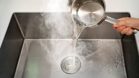 Pouring boiling water down drain
