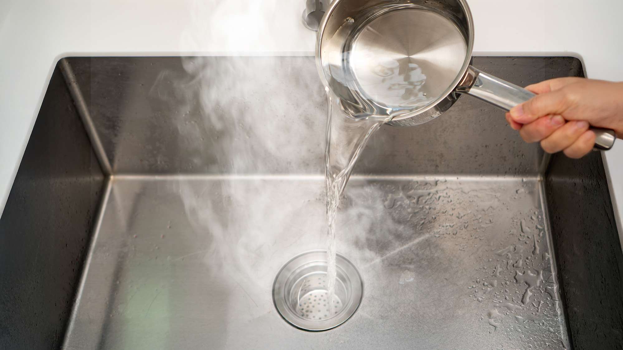 Pouring boiling water down drain