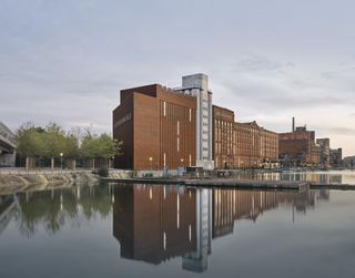 Duisburg’s MKM Museum Küppersmühle is set next to a river. The museum is set in a complex of industrial buildings with a façade of red bricks.