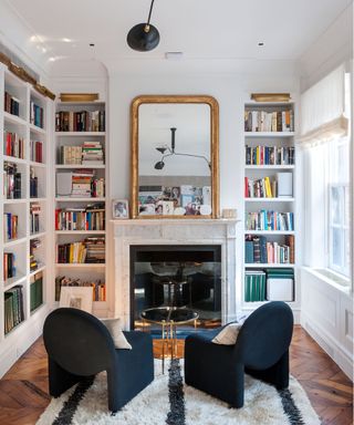 Built-in bookshelves and a pair of armchairs in a white scheme.