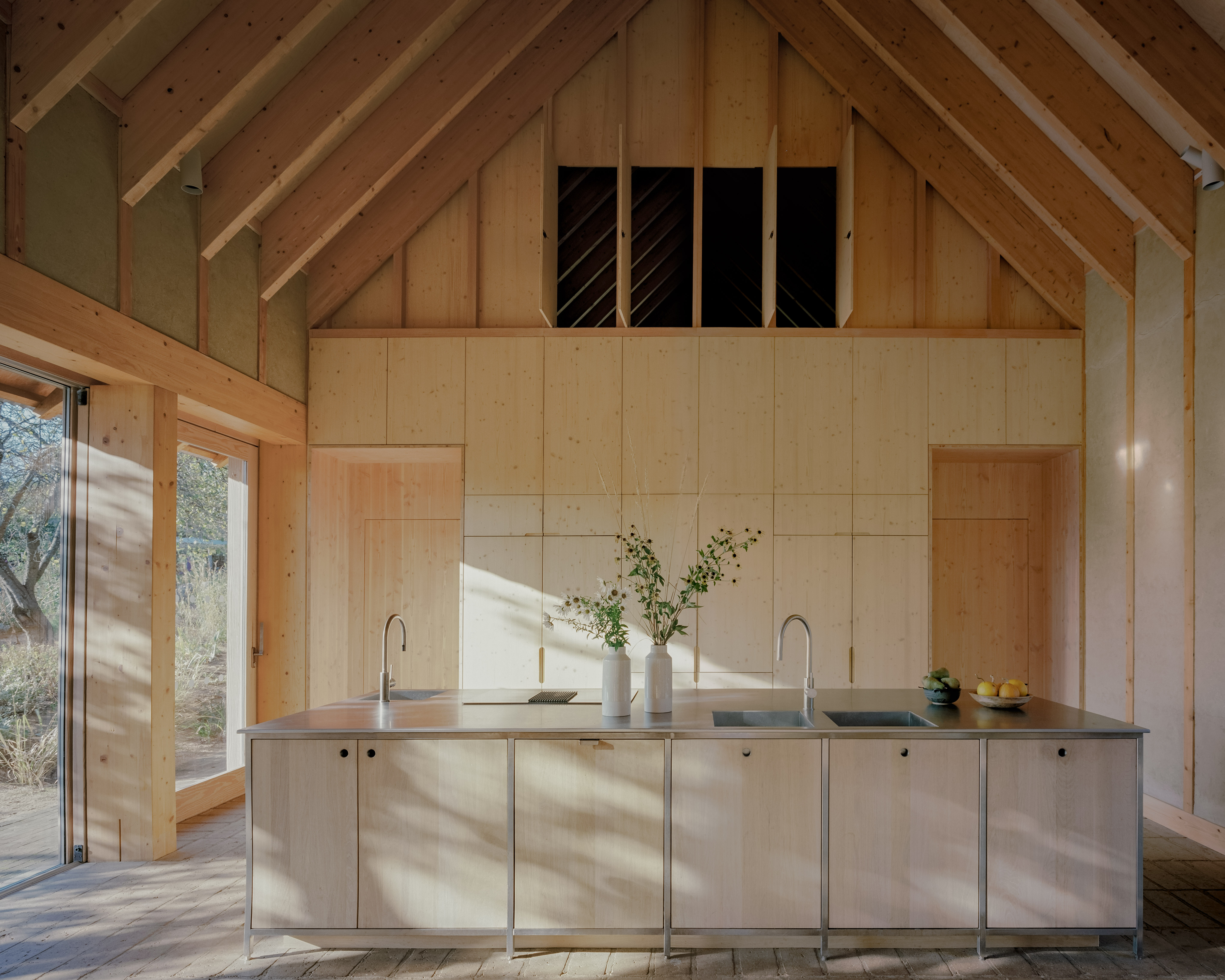 The Apple House, timber building with shingles and pitched roof set among wildflower fields