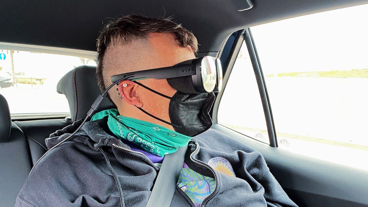 Woman sitting in rear seat of car wearing a VR headset