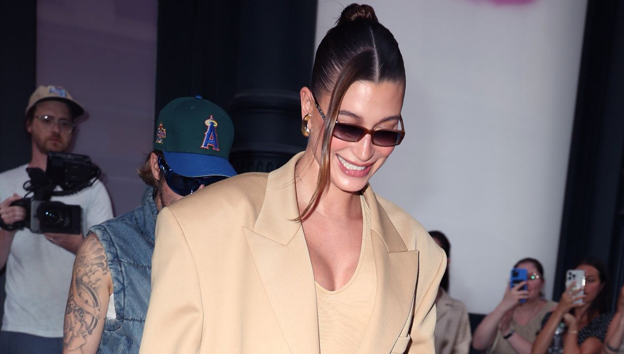 Hailey Bieber wears a blazer and dress while leaving a rhode event contrasting the summer overalls and t-shirt she&#039;ll wear on Instagram