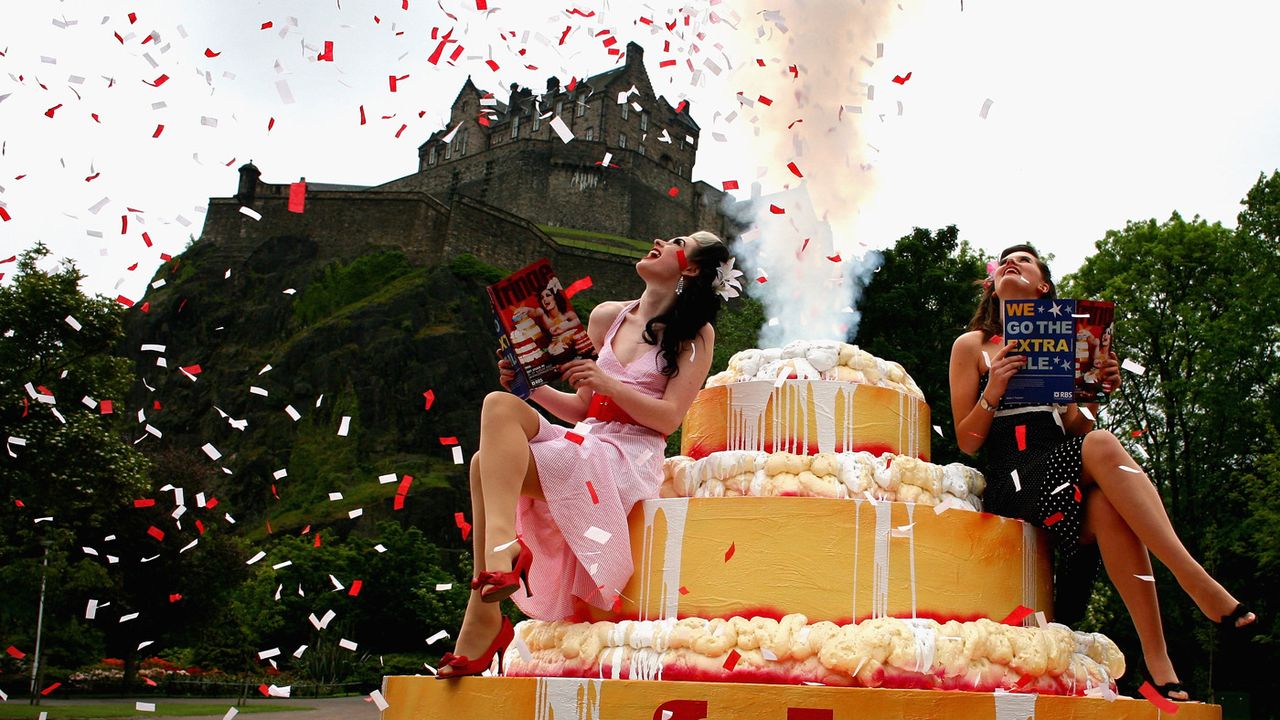 EDINBURGH, UNITED KINGDOM - JUNE 07:Missy Malone (L) and Naomi Howarth sit on a giant cake at the launch of the 2007 Edinburgh Fringe Festival programme June 7, 2007 in Edinburgh, Scotland. T