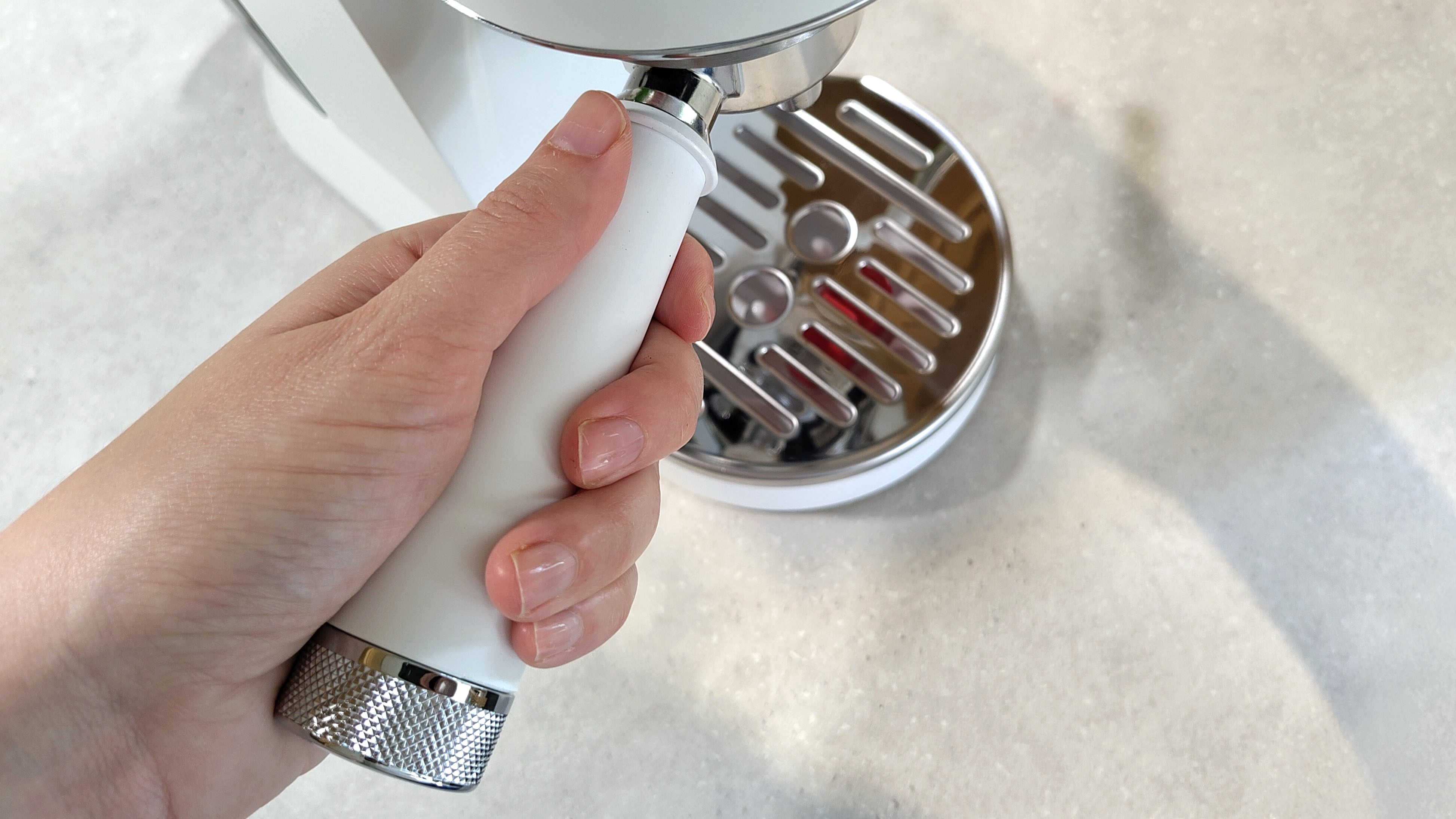 Inserting portafilter handle into De'Longhi Dedica Duo espresso machine