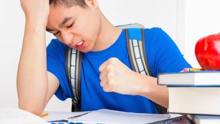 A frustrated teenager clenches his fist.
