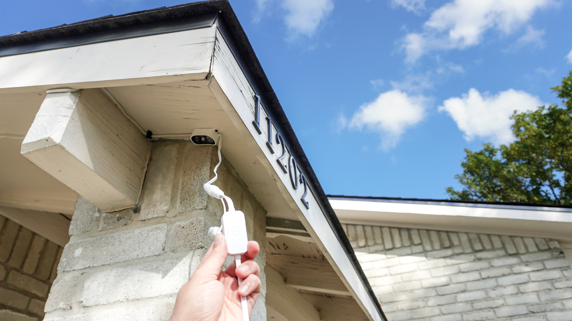 A person holding an extension cable connected to a strand of Govee Prism lights