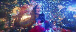 Kamala (Iman Vellani) fantasies about appearing at AvengerCon in her Captain Marvel cosplay, wearing a tiara and holding a bouquet of flowers as she waves to the crowd, confetti erupting behind her