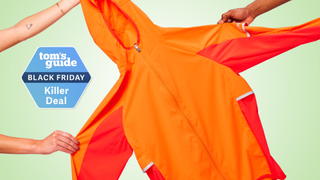 the Altra Trail Wind Jacket being held up by three hands and placed next to a Tom's Guide Black Friday Killer Deal label