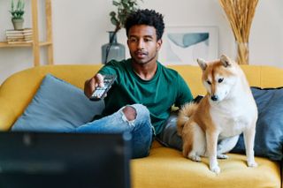 Man watching tv with dog