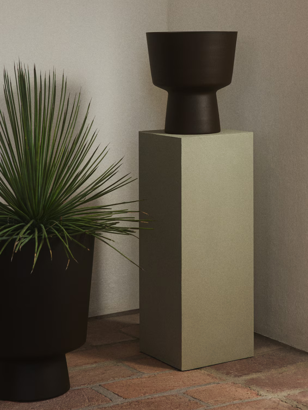 A dark brown metal plant pot from H&amp;amp;M