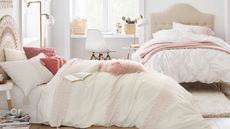 Some of the items in the Pottery Barn Teen bedding sales arranged on two beds in a dorm room with white walls.