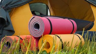 Foam pads rolled up outside a tent