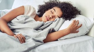 A woman sleeps peacefully on her bed