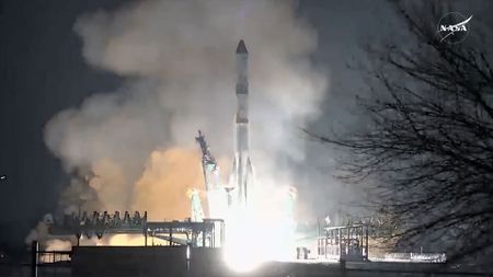 a white rocket lifts off into the night sky