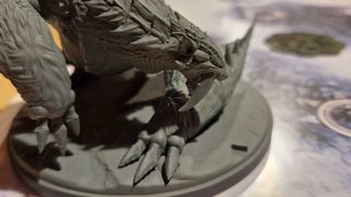 A closeup view of a saber-tooth monster model in Monster Hunter World Iceborne: The Board Game
