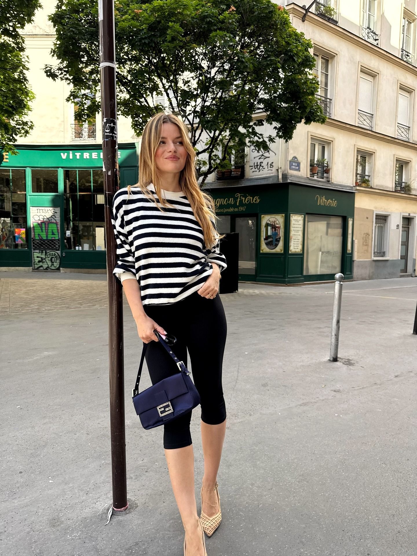European influencer wearing a striped shirt and capri pants