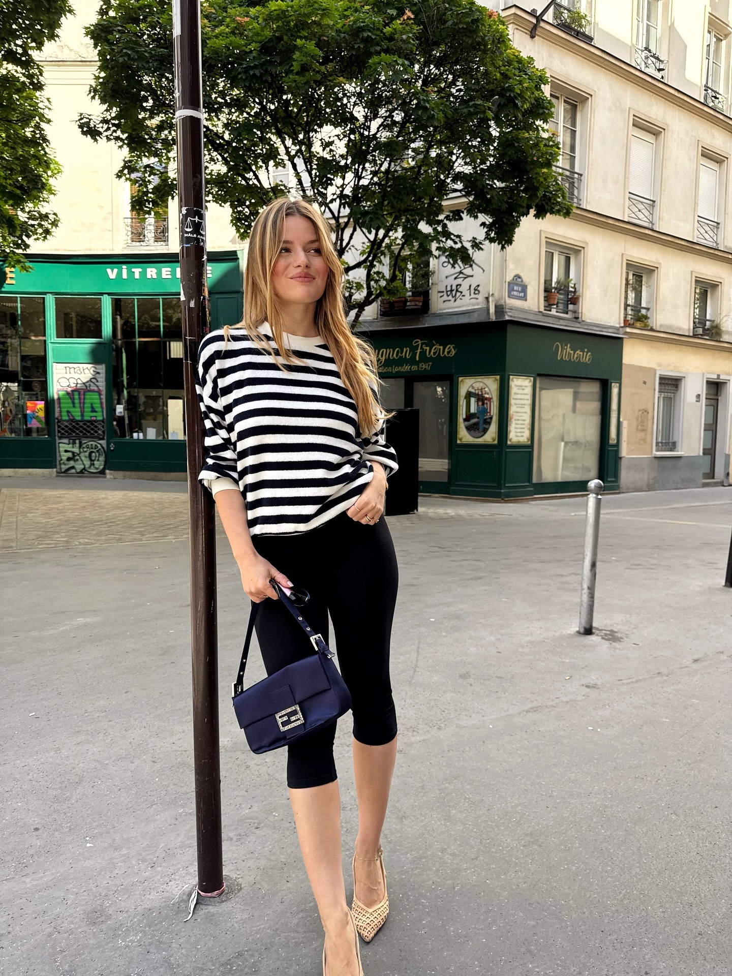 European influencer wearing a striped shirt and capri pants