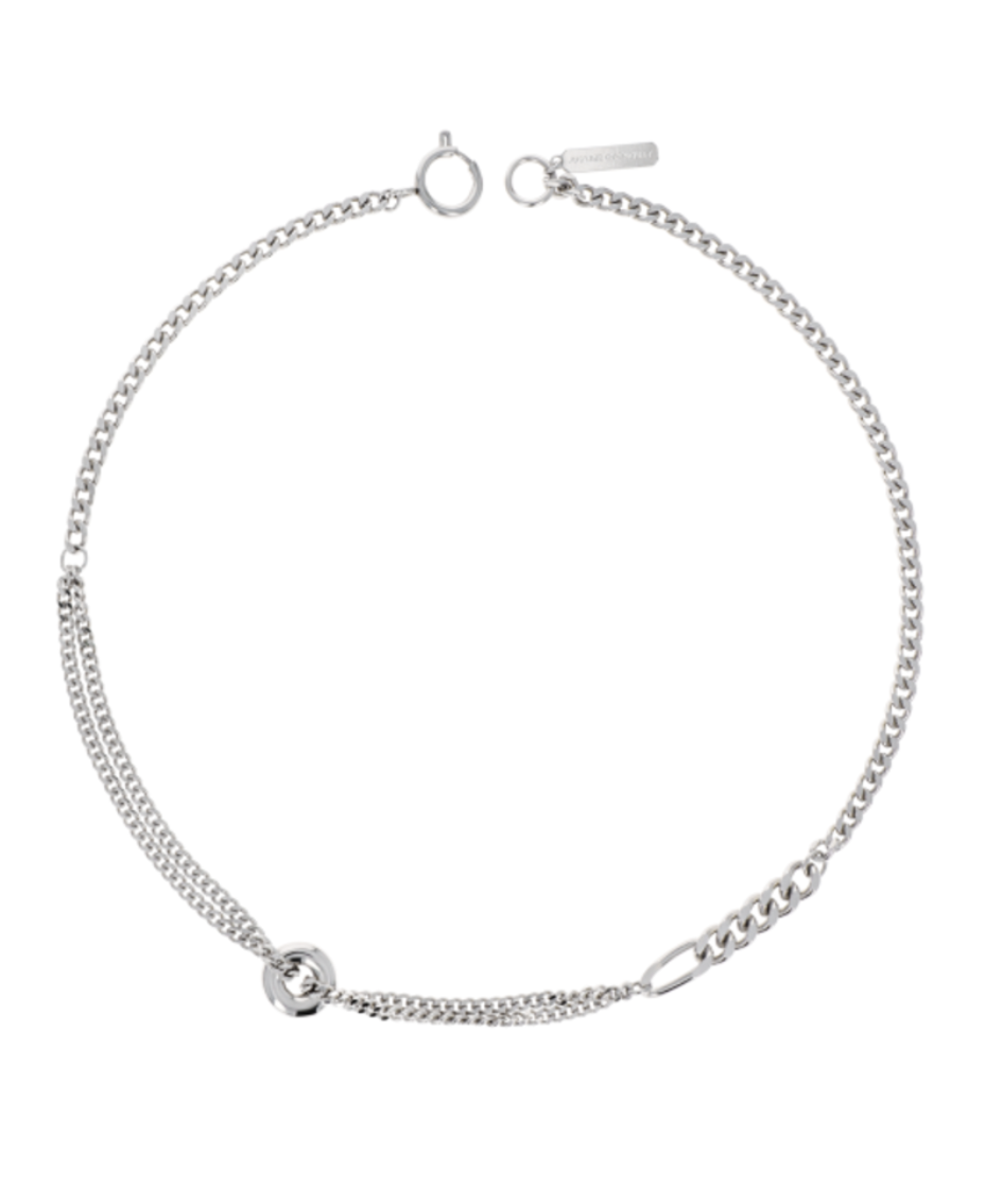 a silver chain necklace in front of a plain backdrop