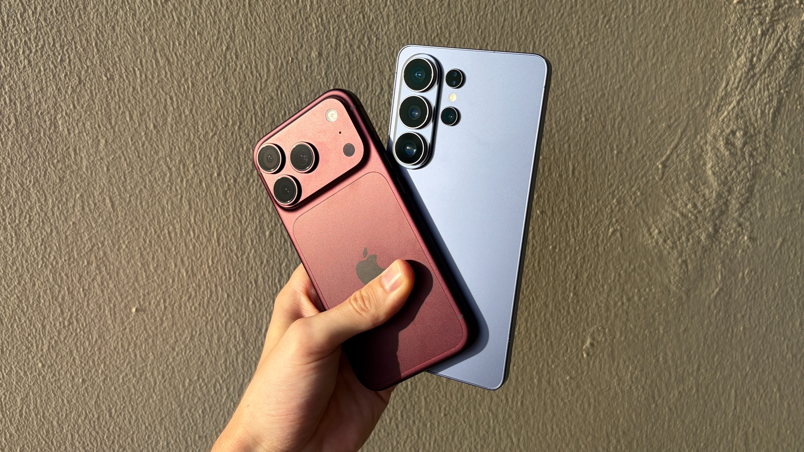 The iPhone 18 Pro and Samsung Galaxy S26 Ultra being held in the hand