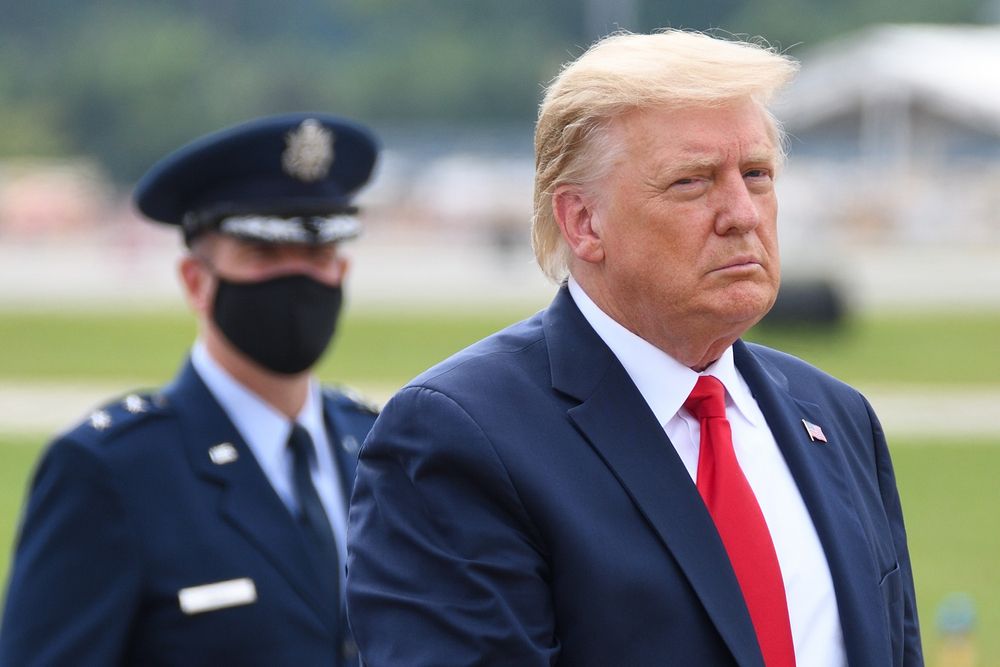 President Donald Trump escorted by a guard