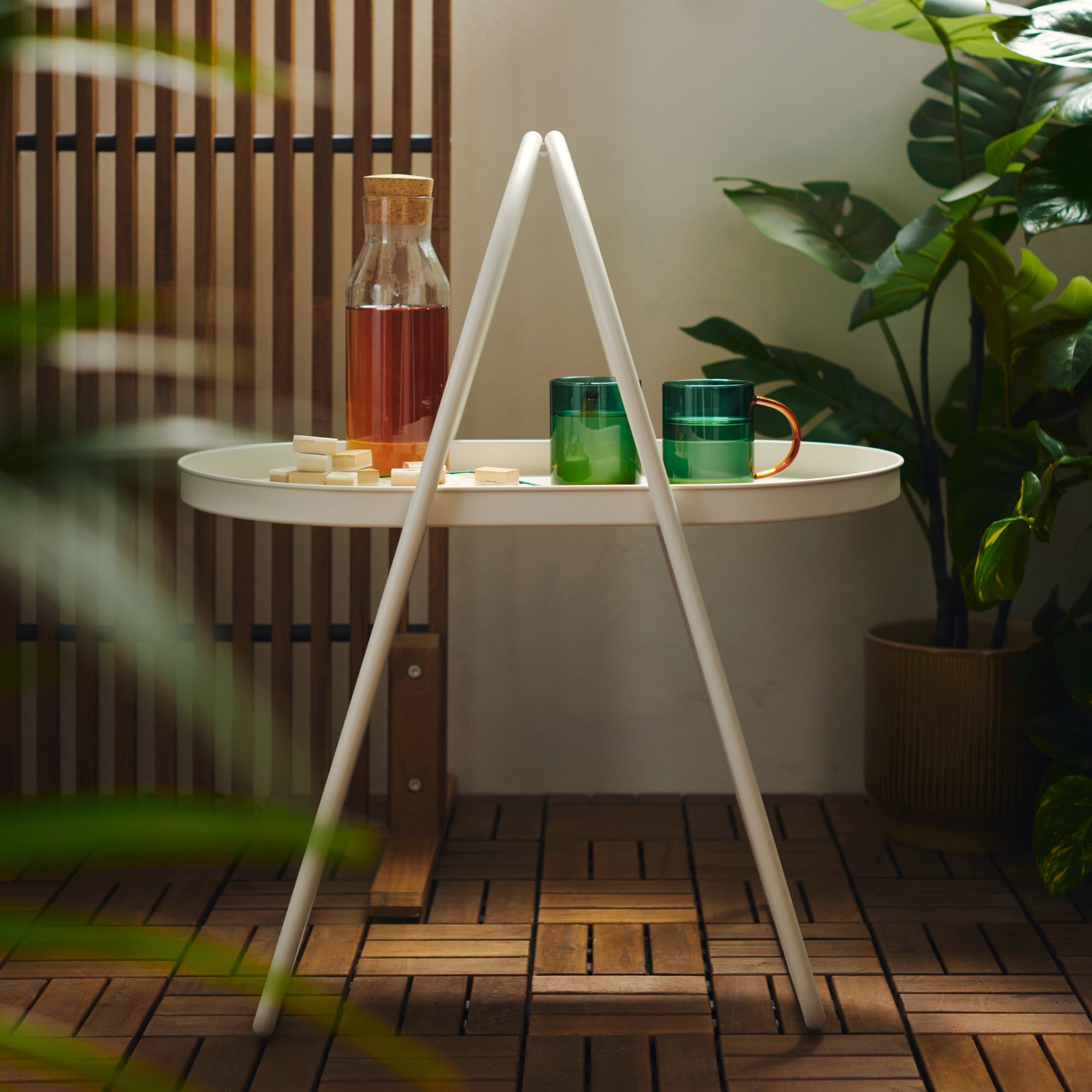 IKEA's outdoor coffee table with green mugs on top of it