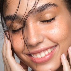 Best Salicylic Acid Face Wash - woman smiling with hands on face and hydrated skin