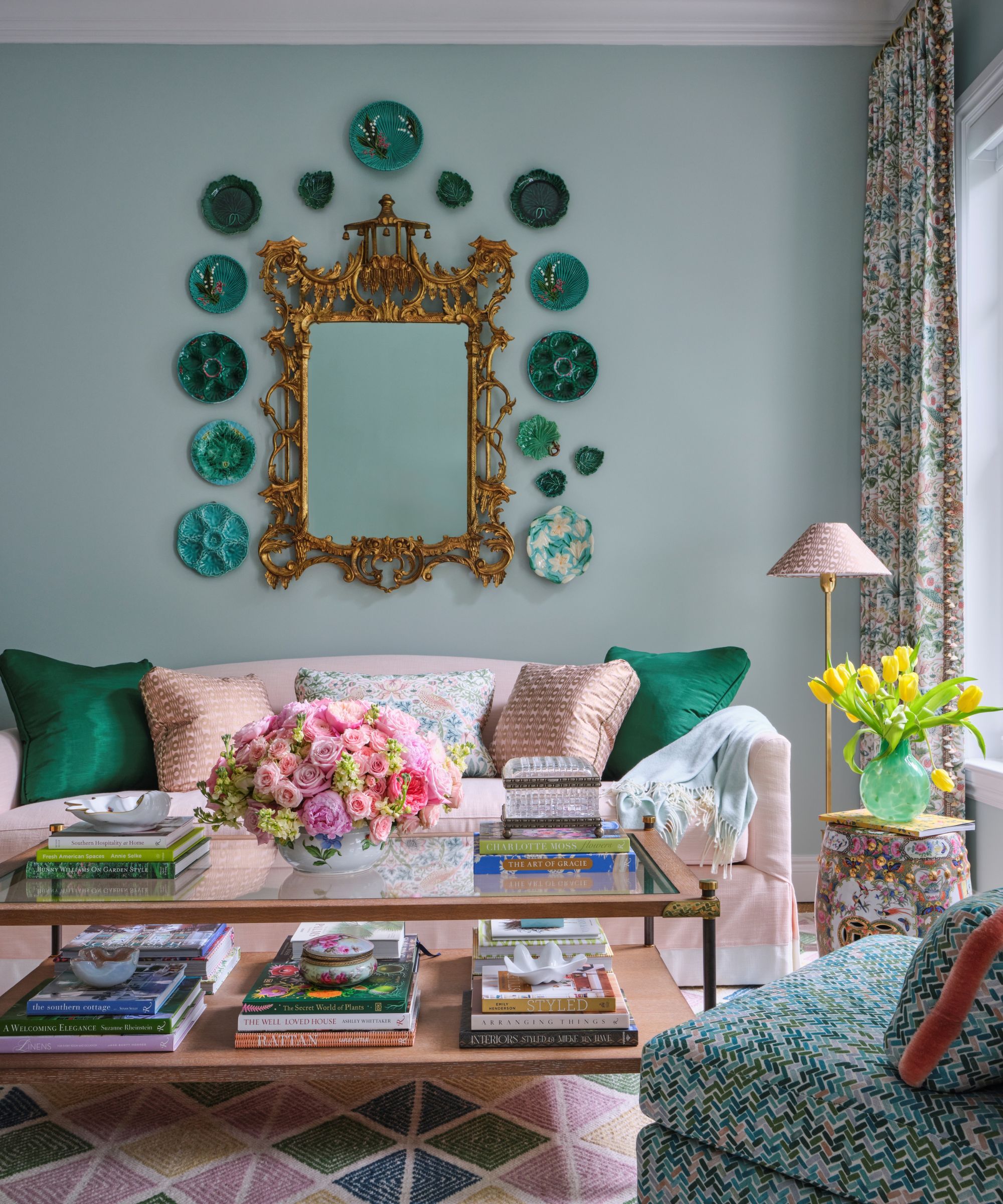 A blue living room with a pink sofa and an antique coffee table