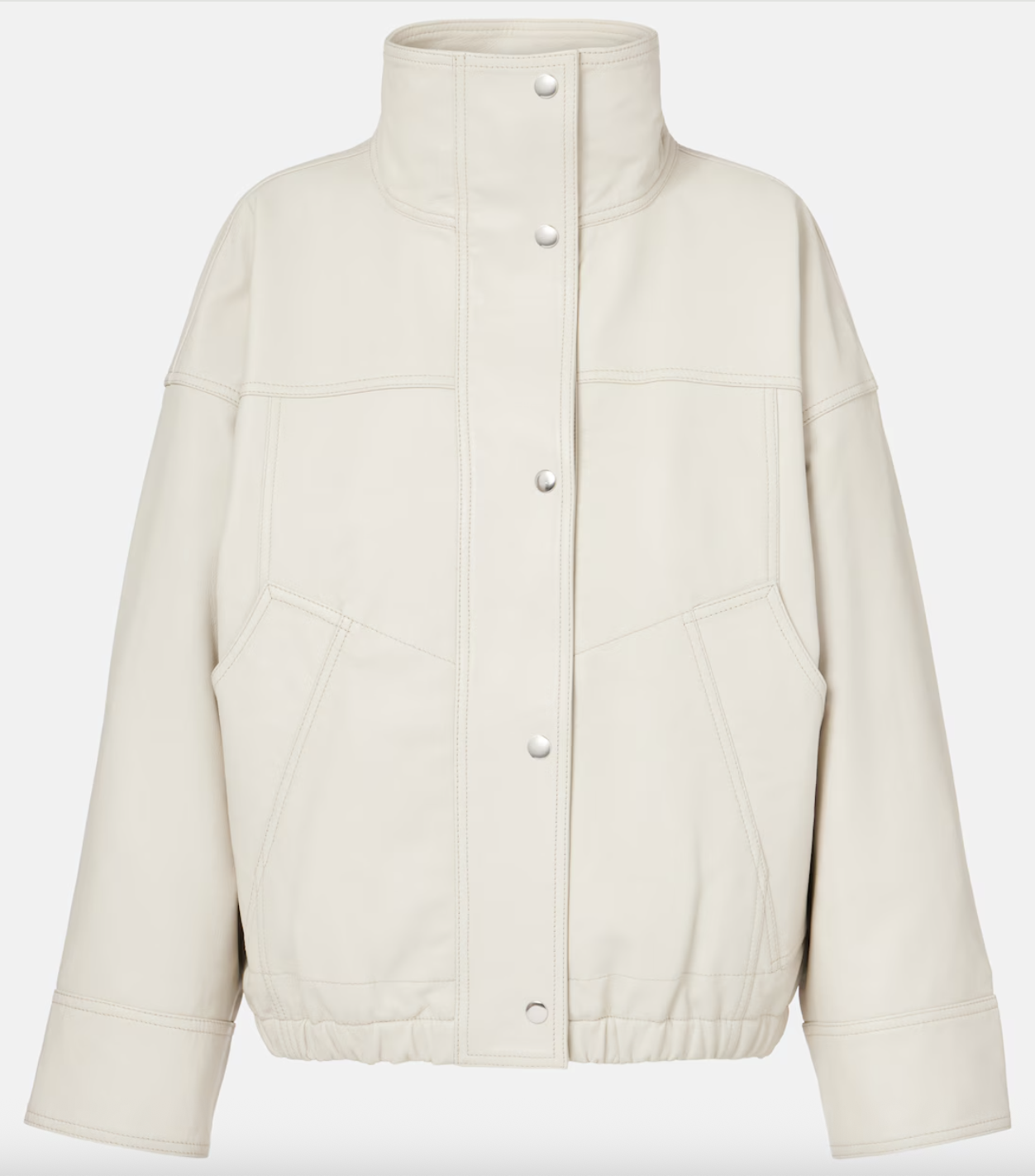 a cream coat in front of a plain backdrop