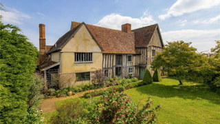 A timber-framed house surrounded by gardens