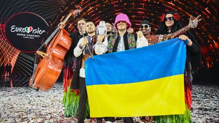  Members of the band Kalush Orchestra pose onstage with the Ukrainian flag