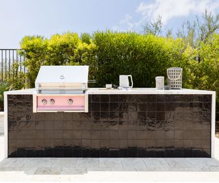 small outdoor kitchen with pink built-in grill