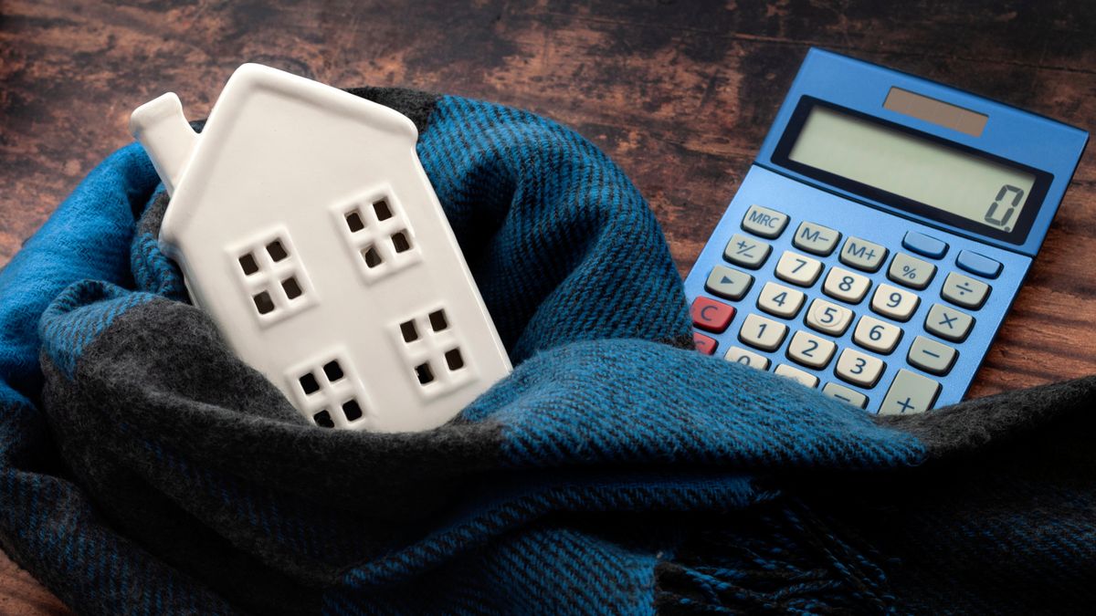 blue scarf wrapped around ceramic 3d house model with blue calculator placed next to it