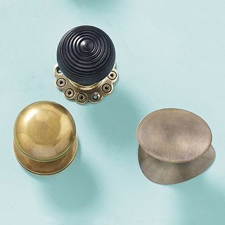 Antique simple brass doorknobs with a light blue background