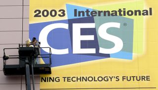 Workers hang a giant poster on the front of the Las Vegas Convention Center for the 2003 International CES January 8, 2003 in Las Vegas. The show, which opened January 9, and was expected to draw over 100,000 people to see the latest in consumer electronics.