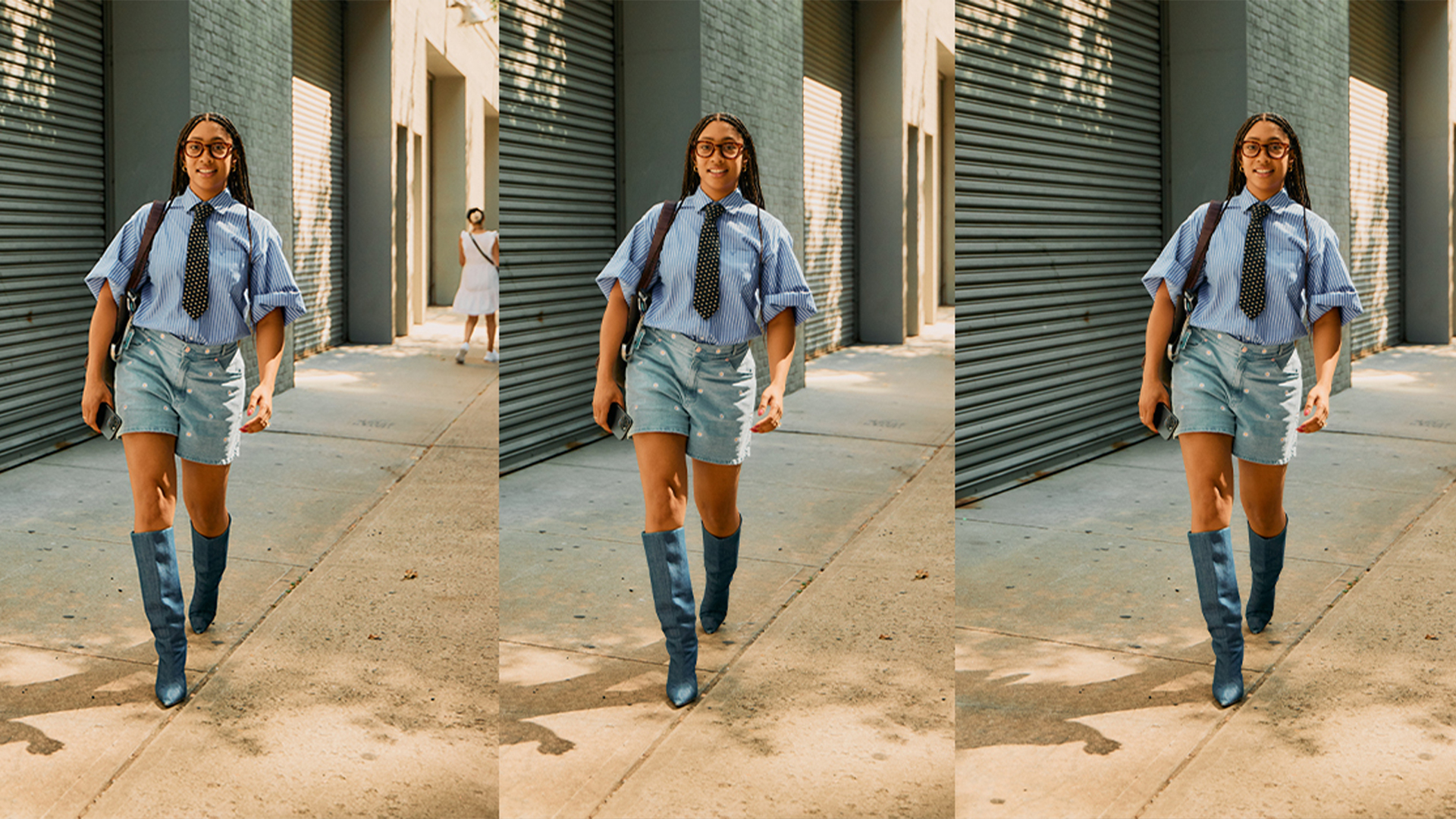Woman wears short sleeve blue-striped button down with a tie, mid-length denim shorts, and tall denim boots while walking. 