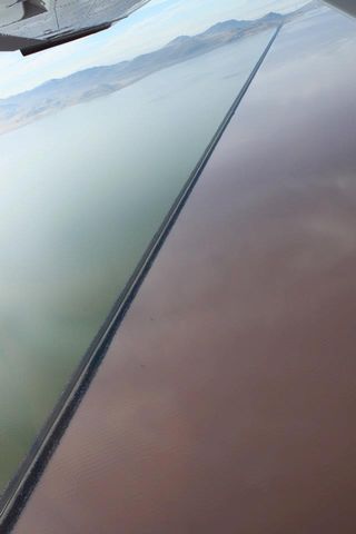 An aerial shot shows the causeway that divides the northern and southern parts of the Great Salt Lake. The rosy color of the northern waters is the result of the pigmented, salt-loving microbes.