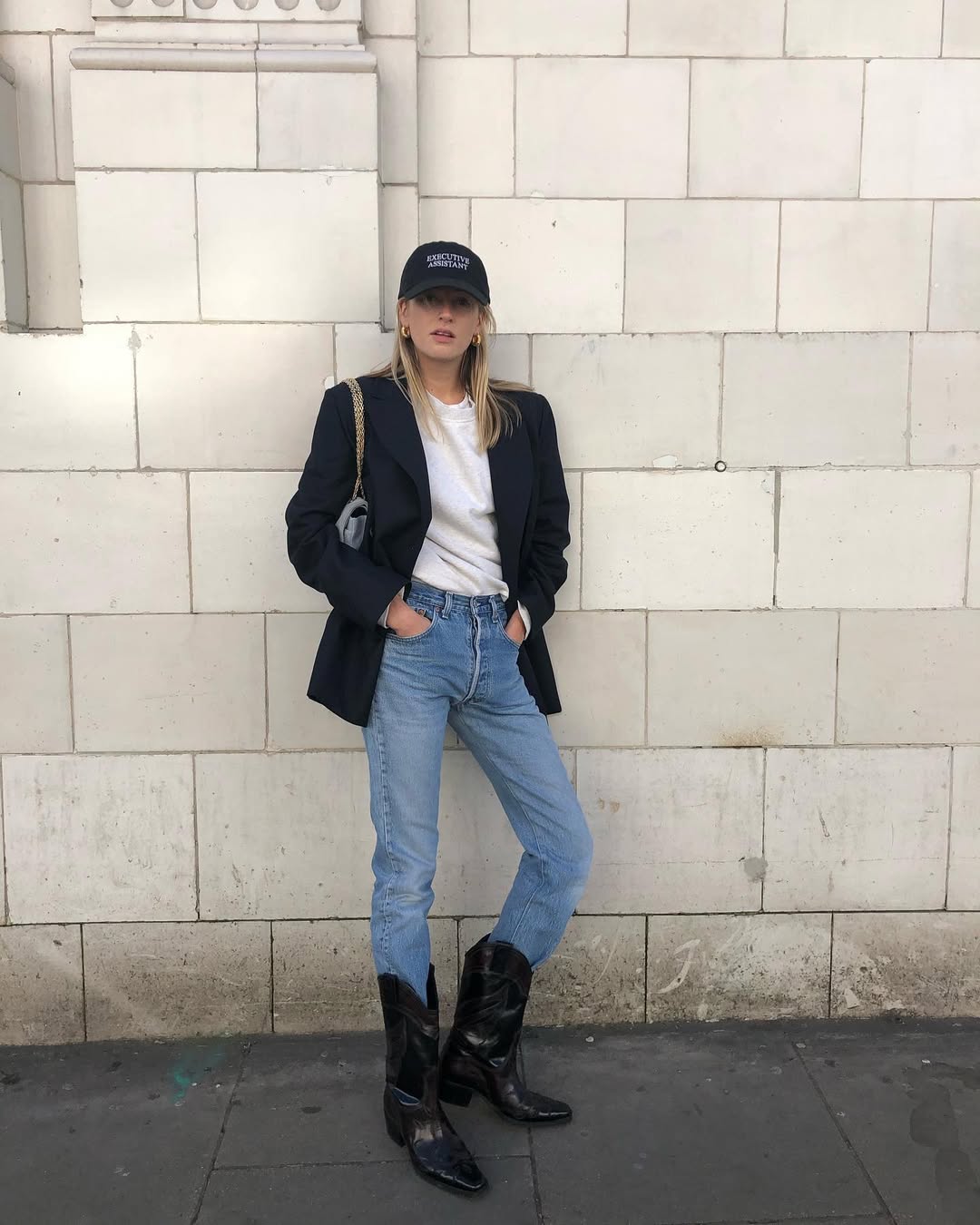 Woman wearing jeans tucked into boots trend fall 2025.