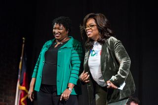 Oprah Winfrey and Georgia Democratic Gubernatorial candidate Stacey Abrams greet the audience during a town hall style event at the Cobb Civic Center on November 1, 2018 in Marietta, Georgia. Winfrey travelled to Georgia to campaign with Abrams ahead of the mid-term election.