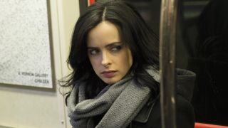 Krysten Ritter as Jessica Jones sitting in subway