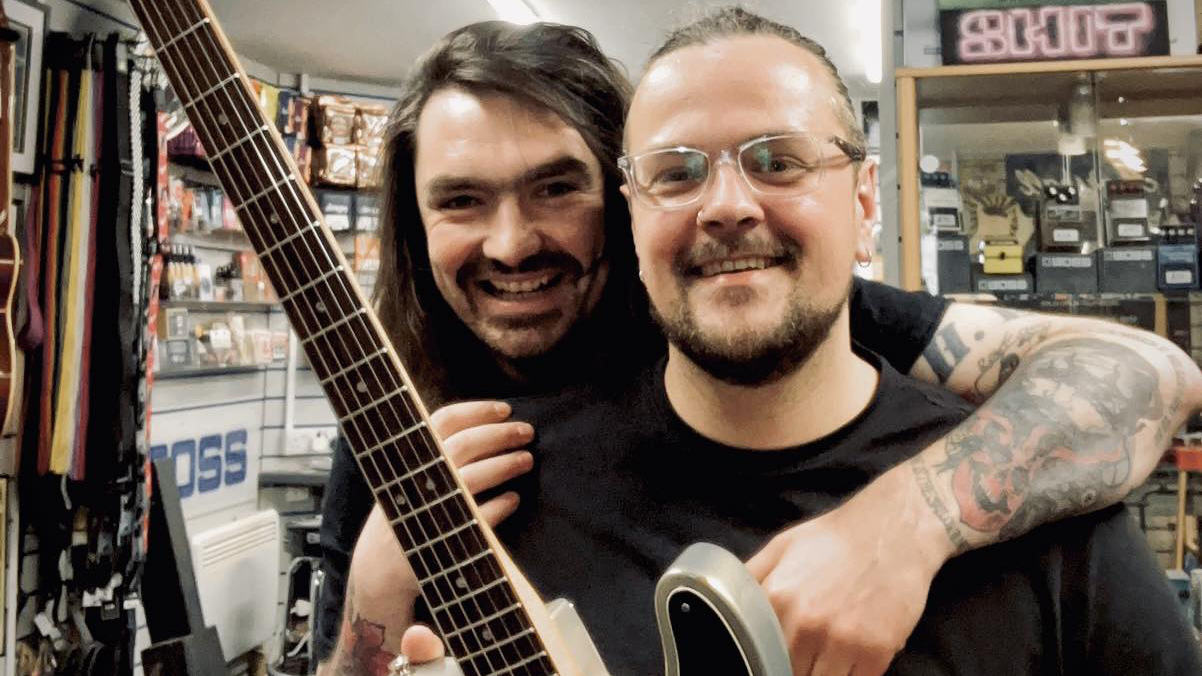 A photo of Mark Wood (right) and Sam Orr. Wood had Orr, owner of Sam's Guitars in Cheshire, England, place some of his father's ashes into the fret markers of the Fender Telecaster he's holding in this photo.