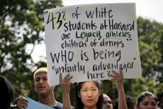 A Harvard student holds a sign during a protest against the Supreme Court