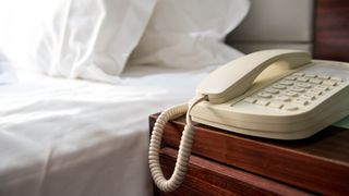 A phone by the bed in a hotel room