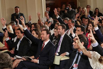 Reporters wait to ask questions at a press conference. 