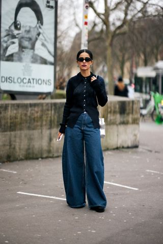 woman wearing cardigan, barrel jeans, and boots