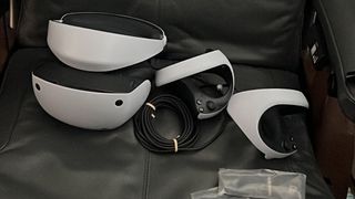 Image of a PS VR2 dev kit with headset and controllers in a chair