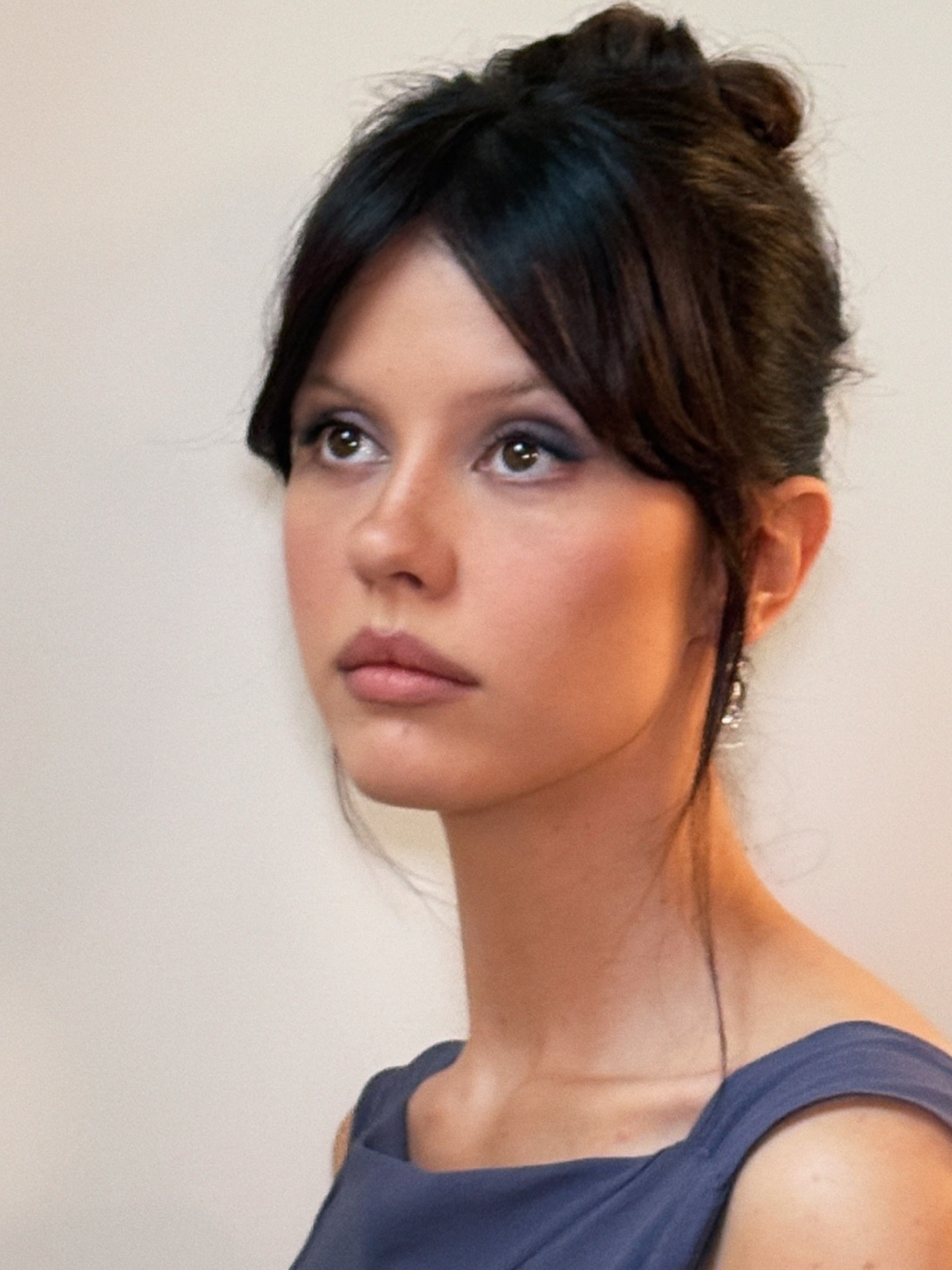 Mia Goth wearing an updo hairstyle with curtain bangs