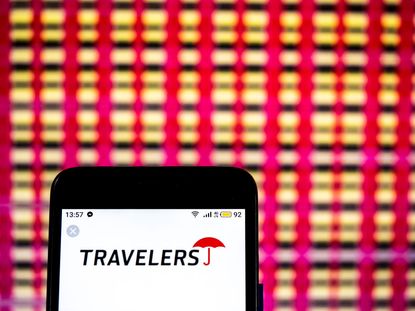 Travelers Insurance logo on smartphone with red and white checked background
